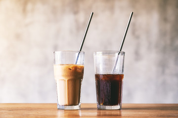 Two glasses of iced coffee with stainless steel drinking straw on wooden table