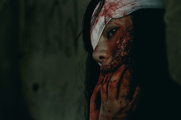 Close-up zombie women looks at her with resentment in an abandoned building, Halloween murder...