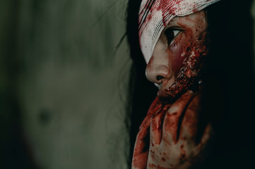 Close-up zombie women looks at her with resentment in an abandoned building, Halloween murder...