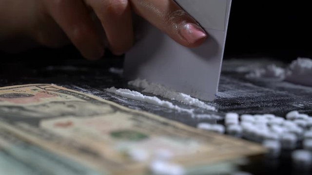 White cocaine powder on a table with dollar bills