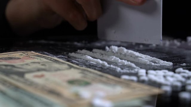 White cocaine powder on a table with dollar bills