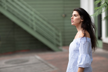 A profile portrait of a young and confident white woman looking up inspiringly with her chin up