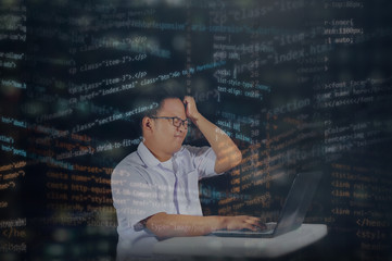 Young male student wearing typical school uniform getting tired or stressed out after hours of writing codes for developing website or HTML project. Shot inside an office at night with overlay codes