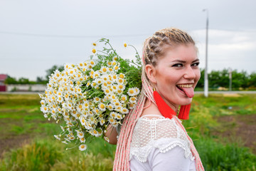 Young girl with a bouquet of daisies in a field. Daisies on a poppy field.