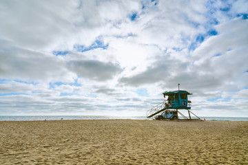 Fototapeta premium Sand Beach, Dramatic Cloudy Sky, and Lifeguard Tower