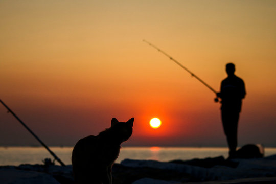 A fisherman silhouette fishing at sunset. Freshwater fishing, catch of fish