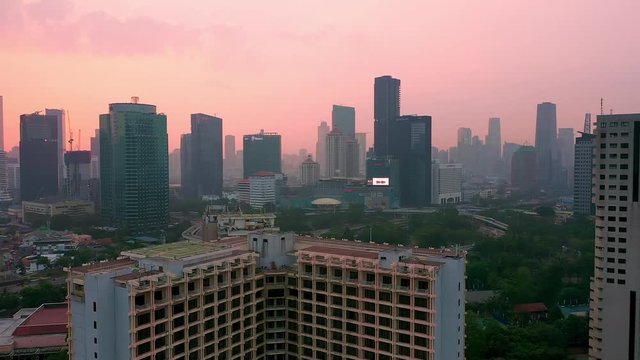 reverse-Reveal Shot drone of Jakarta City, showing aerial view with high pollution air around senayan and semanggi area. Drone Landing
