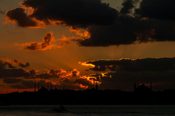 Cityscape of Istanbul with silhouettes of ancient mosques and minarets at sunset. Panoramic view, The Maiden's Tower, Galata Tower, Hagia Sophia, The Blue Mosque and Topkapı Palace in Istanbul.