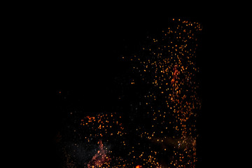 Sparks from a fire on a black background isolate. Concept fire grill heat weekend barbecue.