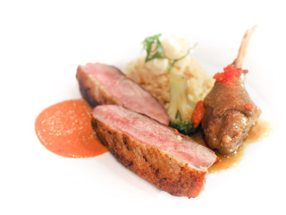 Roasted duck or goose served with fried rice and chili sauce or tomato sauce on white plate, Modern fusion cuisine.