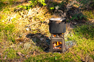 Pot boiling on twig stove outdoors