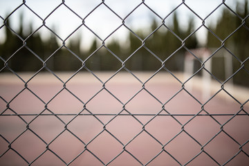 Fototapeta premium wire fence at sunset with unfocused background