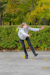 Young beautiful woman is playing with autumn leaves in the park