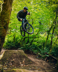 Fototapeta na wymiar Man Jumping at Duthie Hill Mountain Bike Park in Washington State