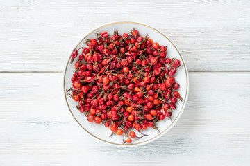 Berries of red rose hips useful for health on a wooden surface