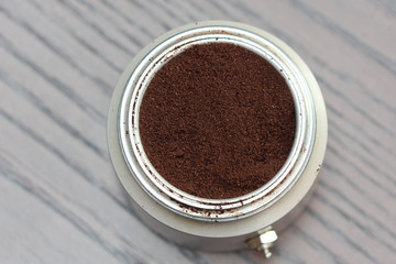 Natural coffee powder in aluminum cans on wooden table, top view.