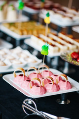 portions of mousse creamy desserts with chocolate. various snacks in three-storey services. Sweets, saltwater, cheese  balls, pickles, cheese tree, chocolate mousse, served on trays