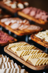 portions of mousse creamy desserts with chocolate. various snacks in three-storey services. Sweets, saltwater, cheese  balls, pickles, cheese tree, chocolate mousse, served on trays