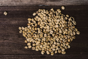Organic Raw coffee beans on wood table.