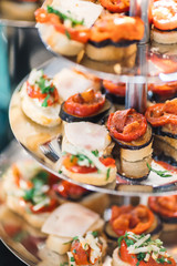 portions of mousse creamy desserts with chocolate. various snacks in three-storey services. Sweets, saltwater, cheese  balls, pickles, cheese tree, chocolate mousse, served on trays