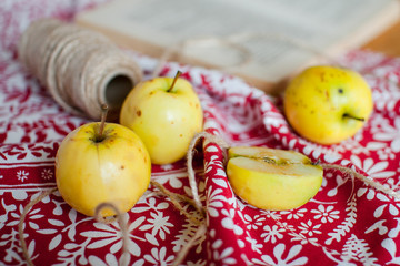 small yellow apples on a beautiful white and red towel