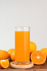 Fresh orange juice glass and fruits  on wood table with white background