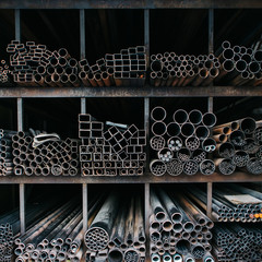 A series of different sizes metal pipes on shelf