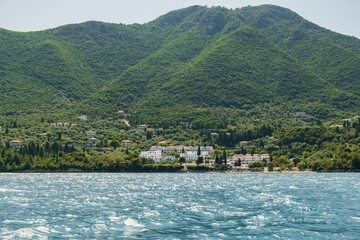 View from the yacht at a small seaside resort town in the mountains of Greece on the island on the coastline in the open sea. Blue sea overlooking the coast of the island. Thracian Sea. Tourism