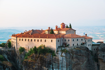 Fototapeta na wymiar Aerial view of a slide from a drone on a panorama of a mountain range. Kalampaka city, Greece. View of the cliffs of Meteora and the monasteries of Meteora. Many ancient Orthodox monasteries
