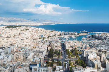 Piraeus, Greece aerial view drone on panorama of buildings of residential and administrative buildings of the city in summer on sunny day. Roof plan aerial view of the blue sea. Front view