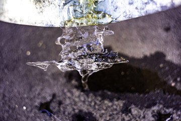 Abstract background with a transparent piece of ice on a metal surface is macro, soft focus