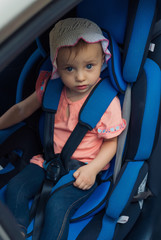 child sitting in a Car Safety Seat looking at camera
