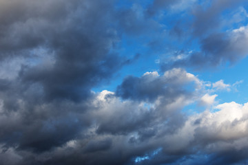 Background of blue sky with dramatic rain clouds.