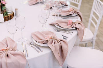 Luxurious wedding table decoration for reception of guests with stylish napkins, cute natural flower