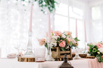 Pink candles in tall glass candlesticks and flowers in a wooden little box