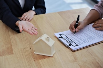 People deal business hand signing document home loan agreement contract on office desk with selective focus