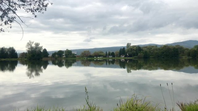 Beautiful fish pond near Badin, Banska Bystrica, Slovakia. Fishing place. Clouds over the lake. Mirror reflection in standing water.