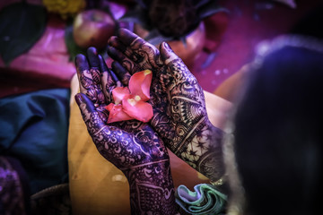 henna on female bride hands with flowers