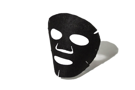  Face mask made of sheet fabric. Black mask for facial skin. On a white background with a shadow. Cosmetology, medicine and healthcare.