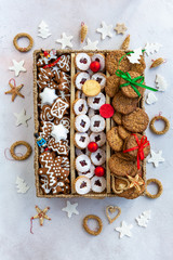 Christmas cookies gift box with decorative pendants arranged around the box, flat lay, directly above