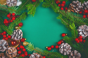 Christmas background with cones and pine branches on green