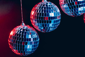 Sparkling disco balls hanging in the air against black background