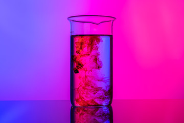 Laboratory glass tubes with chemicals on bright pink background