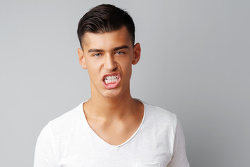Portrait of angry irritated young man teenager