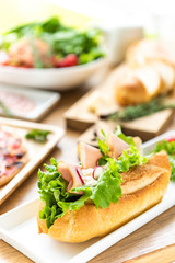テーブルにならぶサンドイッチとサラダ