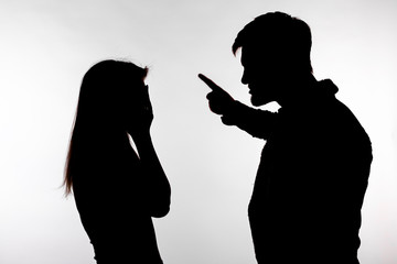 Aggression and abuse concept - man and woman expressing domestic violence in studio silhouette...