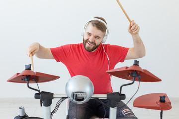 Music, people and hobby concept - man drummer playing the drum and looks like very emotional