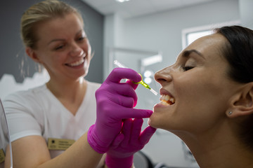 Periodontist cleans interdental space with a dental brush for his patient