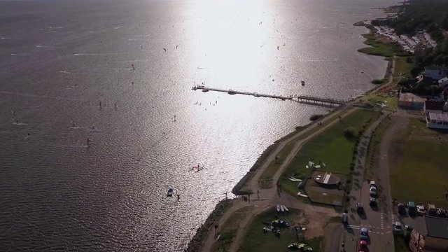 Many Surfers and kite-surfers having fun on hel peninsula; aerial view.