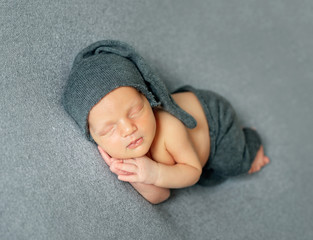 Newborn sleeping on dark background